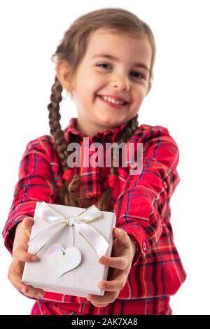 Happy little girl holding gift box in hands on white background. Stock Photo