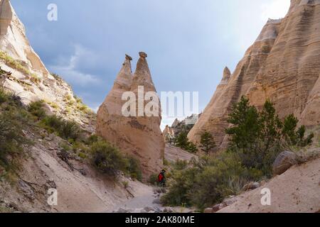 A hiking trail winds along the canyon floor next to the cone shaped spires of the Tents Rock National Monument. Stock Photo