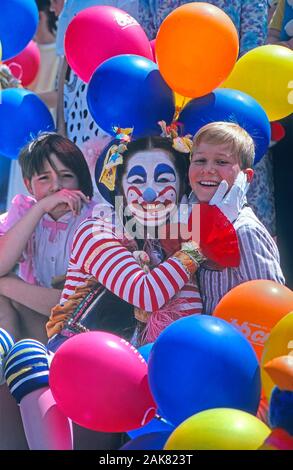 Female clown posing and laughing with two children Stock Photo