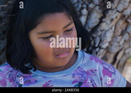 The facial expression of a young girl who is sad, upset or bullied. Stock Photo
