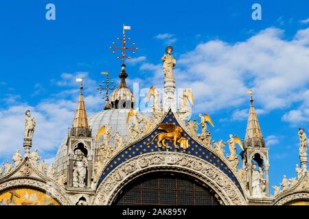 The facade of St Marks Basilica featuring Christ and angels along with the Lion of St Mark in Venice Italy Stock Photo