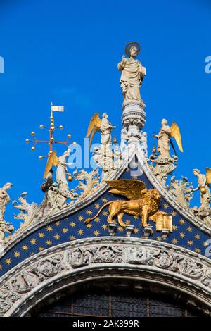 St Marks Basilica featuring ornate gold statues of Christ and angels along with the Lion of St Mark in Venice Italy Stock Photo