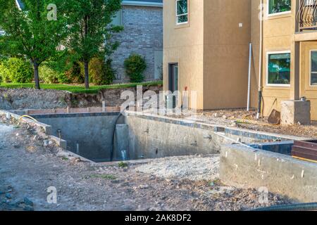 Construction of a residential swimming pool with houses and trees background Stock Photo
