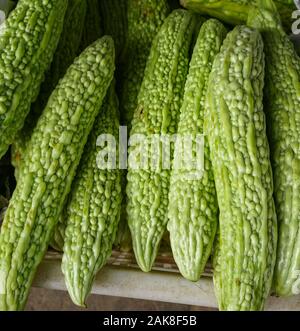 Selling bitter melon fruits at street market in Fenghuang Ancient Town (China). Stock Photo