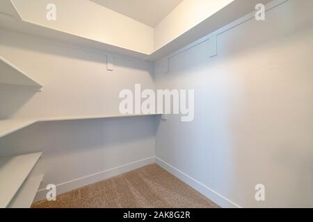 Empty white shelves inside a walk in cupboard Stock Photo