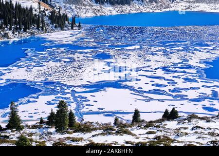 Bizarre forms of ice on a frozen mountain lake, guessing the shape of a beagle dog at the front edge of the lake; variety of shapes in nature concept Stock Photo