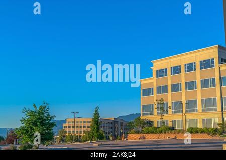 Empty parking lot with buildings mountain and blue sky view on a sunny day Stock Photo