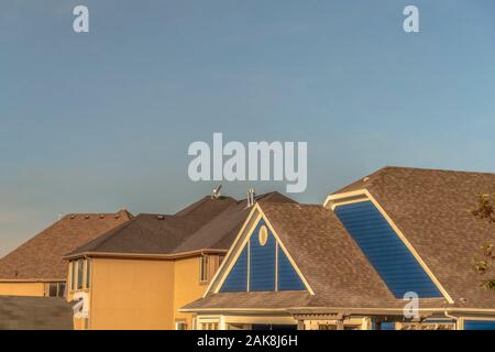 Dark color roof of houses viewed against cloudless blue sky on a sunny day Stock Photo