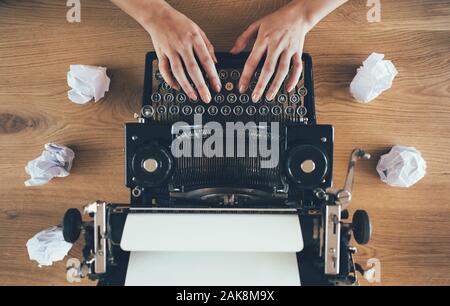Writer typing on vintage typewriter with crumpled papers around. Inspiration problem concept Stock Photo