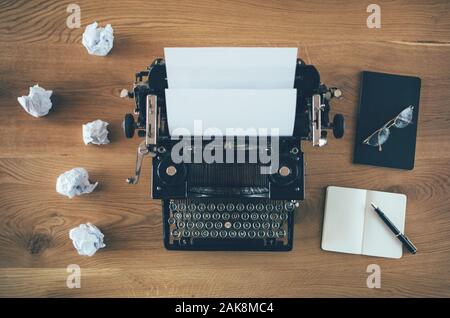 Vintage writer's desk with typewriter with crumpled papers Stock Photo