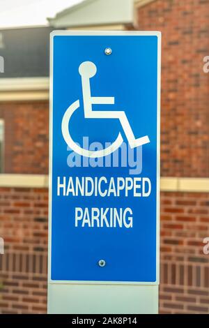 Close up of Handicapped Parking sign against blurred red brick wall of church Stock Photo