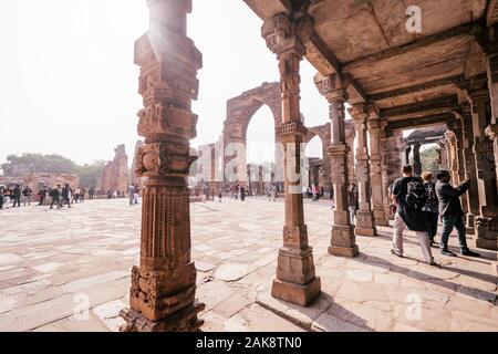New Delhi, India - January 5, 2020: Tourists enjoy Qutub Minar complex and ruins Stock Photo
