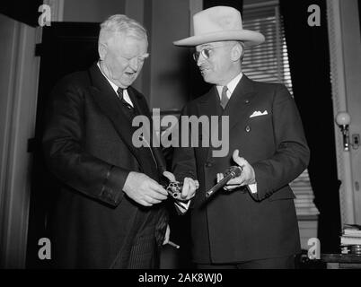 Vintage photo of US Vice President John Nance Garner (left) being shown a pair of 45-caliber pistols by Missouri Senator - and future President - Harry S Truman. The guns were said to have been once owned by the notorious outlaw Jesse James and had been obtained by Truman from the wife of a doctor who had been given them by Jesse’s brother Frank as payment for medical services. Photo by Harris & Ewing taken in Washington DC on February 17 1938. Garner (1868 – 1967) was the 32nd Vice President (1933 – 1941) and Truman (1884 – 1972) would later become the 33rd US President (1945 – 1953). Stock Photo