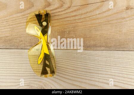 Protective glasses weigh on a wooden wall. Stock Photo