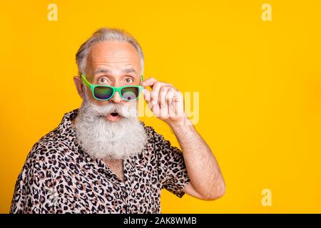 Close up photo of astonished man seeing something strange in front of him while isolated with yellow background Stock Photo