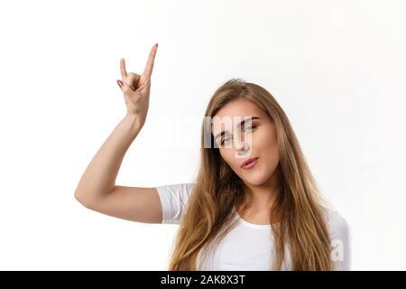 smiling young woman showing rock and roll hand and looking at camera on white background. Stock Photo