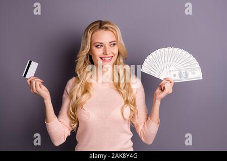 Portrait of nice attractive lovely cheerful cheery wavy-haired girl client holding in hands fan of 100 usd bank plastic card investment isolated over Stock Photo