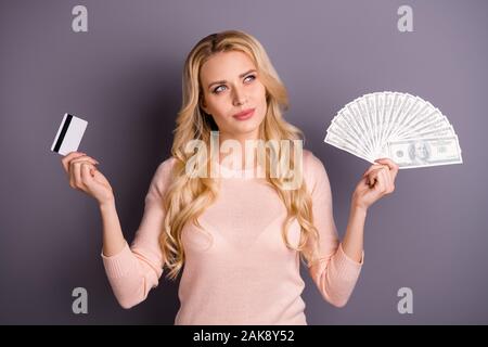 Portrait of nice attractive lovely winsome wavy-haired girl holding in hands fan of 100 usd bank plastic card deciding how to spend isolated over gray Stock Photo