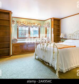 Square Golden lit bedroom of luxury California home with beige carpet Stock Photo