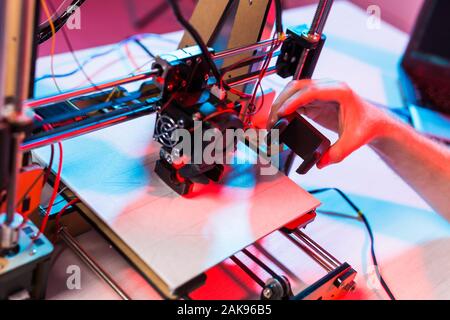 Young male designer engineer using a 3D printer in the laboratory and studying a product prototype, technology and innovation concept. Stock Photo
