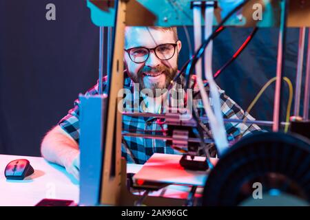 A student man print prototype on 3D printer. Stock Photo