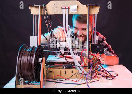 A student man print prototype on 3D printer. Stock Photo