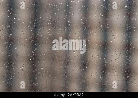 Raindrops on window glass, blurred striped background. Stock Photo