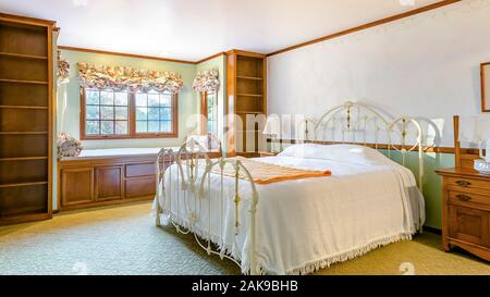 Panorama frame Golden lit bedroom of luxury California home with beige carpet Stock Photo