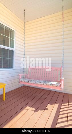 Vertical frame Colorful green rocking chair and pink bench Stock Photo
