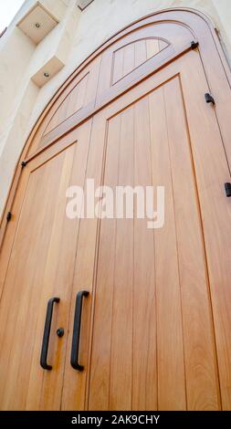 Vertical Low angle close up of an arched wooden door Stock Photo