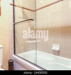 Square Master bath in luxury home with large glass shower bright and clean Stock Photo