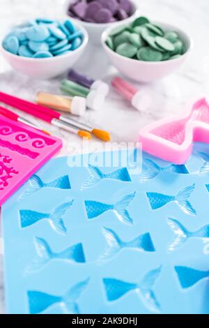 Flat lay. Ingredients to make chocolate mermaid molds from the chocolate chips. Stock Photo