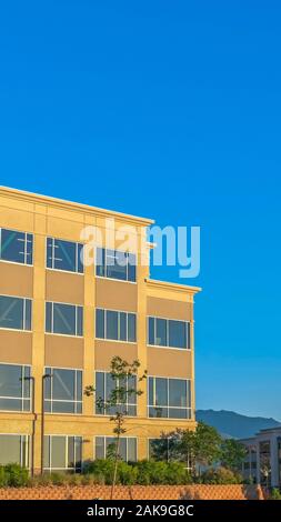 Vertical Empty parking lot with buildings mountain and blue sky view on a sunny day Stock Photo
