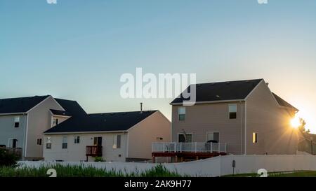 Exterior view of lovely homes with bright sun and blue sky background ...