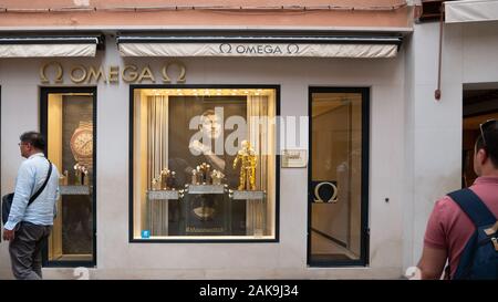 Venice Italy 08 14 2019 tourists look around in front of a shop selling luxury omega watches Stock Photo