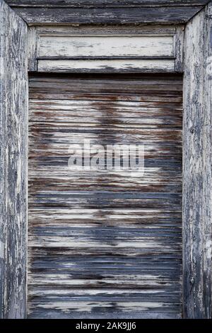 Closed, heavily weathered wooden roller blind in portrait format Stock Photo