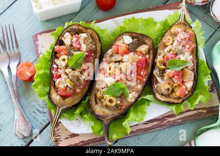 Thanksgiving Autumn Menu. Baked Stuffed Eggplant with Olives, Feta Cheese and Vegetables on a Rustic Table. Stock Photo