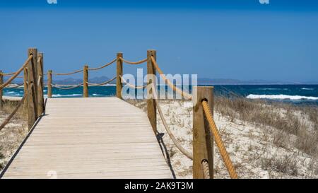 Wooden walking path along the beach, Formentera island. Spain. Wooden footbridge in Formentera island. Stock Photo