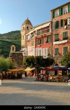 The summer piazza and colourfully painted houses and church architecture of Vernazza, Cinque Terre National Park, Liguria Italy EU Stock Photo