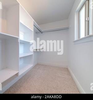 Square frame Empty white fitted interior of walk-in wardrobe Stock Photo