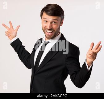 Joyful Business Guy Shouting Gesturing Spreading Hands Standing Over White Background. Studio Shot Stock Photo