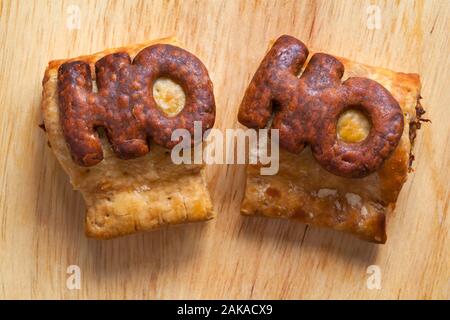 Two M&S Handcrafted Sausage Roll set on wooden board background - Ho - looking down on from above Stock Photo
