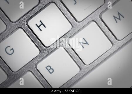 Keyboard - silver portable computer keyboard in IT department with letter H isolated on white button Stock Photo