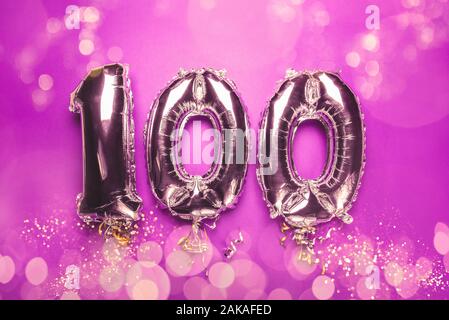 Balloon Bunting for celebration Happy 100th Anniversary made from Silver Number Balloons on pink background with bokeh lights. Holiday Party Decoration or postcard concept with top view Stock Photo