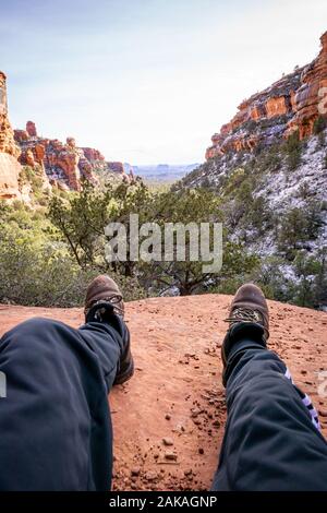 Sedona, Arizona/USA- December 29, 2019: A first-person point of view photo of a person wearing hiking boots in front of red rocks. Stock Photo