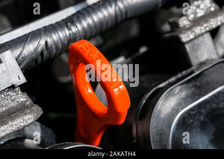 Red oil dipstick in car engine. Measuring level of engine oil. Dipstick oil level gauge with red color for Checking engine oil level of engine system. Stock Photo