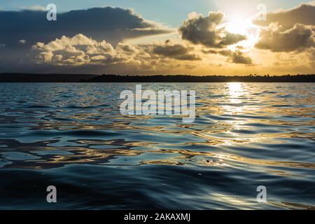 Colour abstract photograph of narrowly focused gently rippling water during sunset, taken on Poole harbour, Dorset, England. Stock Photo