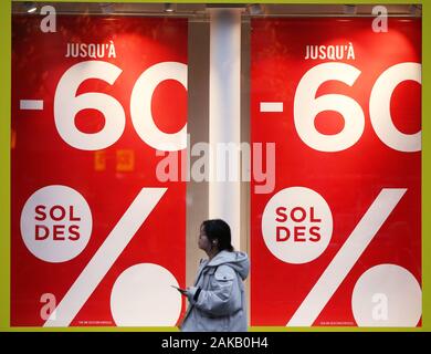 Paris, Jan. 8. 4th Feb, 2020. A woman walks past posters displaying sales information in Paris, France, Jan. 8, 2020. Winter sales in France kicked off on Wednesday and will last to Feb. 4, 2020. Credit: Gao Jing/Xinhua/Alamy Live News Stock Photo