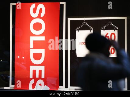 Paris, Jan. 8. 4th Feb, 2020. A woman walks past a poster displaying sales information in Paris, France, Jan. 8, 2020. Winter sales in France kicked off on Wednesday and will last to Feb. 4, 2020. Credit: Gao Jing/Xinhua/Alamy Live News Stock Photo