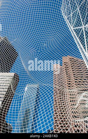 View through big mesh head public art display in front of office tower Stock Photo